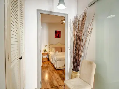 a living room with a bed and a chair at Espalter White by Hello Homes Sitges in Sitges