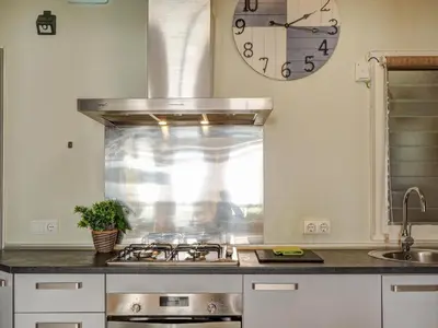 a kitchen with a stove and a clock on the wall at Espalter White by Hello Homes Sitges in Sitges