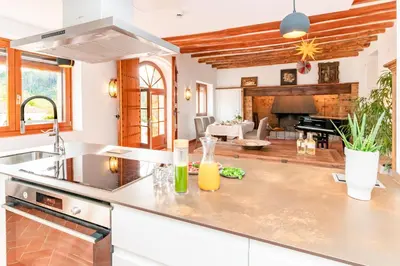 a kitchen with a counter top and a living room at El Huerto - Großzügiges Appartment in Katalanischer Masia in Sant Iscle de Vallalta