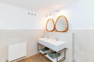 a bathroom with a sink and two mirrors at El Huerto - Großzügiges Appartment in Katalanischer Masia in Sant Iscle de Vallalta