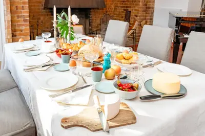 a table with plates and bowls of food on it at Ginkgo - Familienfreundliches Appartment in Katalanischer Masia in Sant Iscle de Vallalta