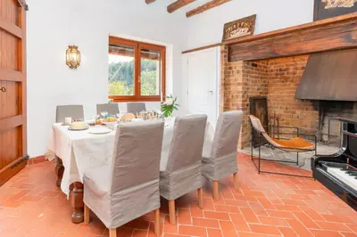 a dining room with a table and chairs and a fireplace at Gallinero - Familienfreundliches Appartment in Katalanischer Masia in Sant Iscle de Vallalta