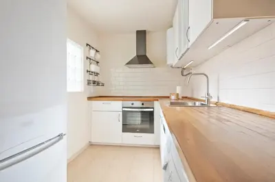 a kitchen with white appliances and a wooden counter top at Alcam Galileu P in Barcelona