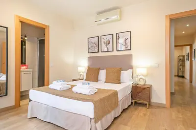 a bedroom with a large bed with towels on it at Alcam Galileu P in Barcelona