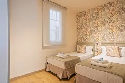 a room with two beds and a window at Alcam Galileu P in Barcelona