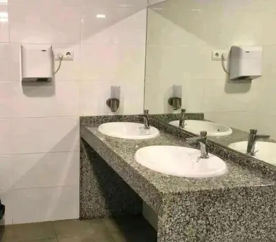 a bathroom with three sinks in a public restroom at Vintage and cozy sailing boat in Barcelona in Barcelona