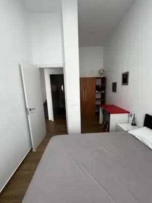 a bedroom with a bed and a red table at Precioso apartamento con magnífico patio. in Sant Feliu de Llobregat
