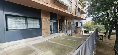 a building with a fence next to a porch at Gran apartamento ideal grupos muy cerca Barcelona in Badalona