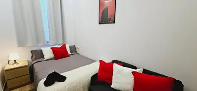 a bedroom with a bed with red and white pillows at Gran apartamento ideal grupos muy cerca Barcelona in Badalona