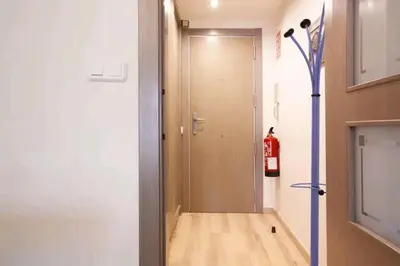 a hallway with a door and a fire extinguisher at Centric Apartment Gran Via 5 in Hospitalet de Llobregat