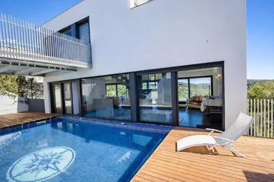 a house with a swimming pool and a chair at Catalunya Casas Modern Hilltop Haven with private pool 7km to beach in Castellet