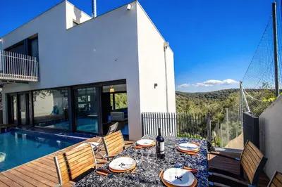 a patio with a table and chairs next to a pool at Catalunya Casas Modern Hilltop Haven with private pool 7km to beach in Castellet