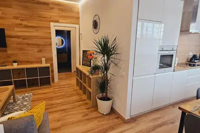 a kitchen and a living room with wooden walls at apartamento premium muy cerca ciudad Barcelona in Badalona