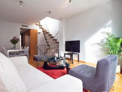 a living room with a white couch and a table at My Space Emirates - Park Güell Triplex with Private Terrace in Barcelona