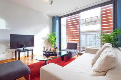 a living room with a couch and a tv at My Space Emirates - Park Güell Triplex with Private Terrace in Barcelona