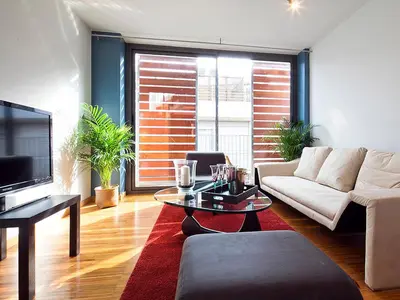 a living room with a couch and a tv at My Space Emirates - Park Güell Triplex with Private Terrace in Barcelona