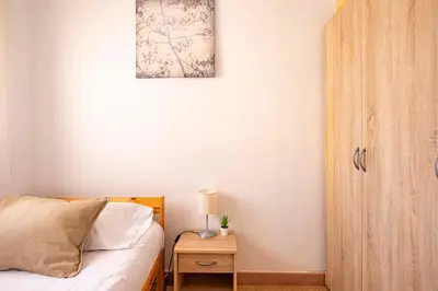 a bedroom with a bed and a table with a lamp at Apartamento 3 hab 15 minutos de Barcelona centro y 5 minutos playa in Sant Adria de Besos