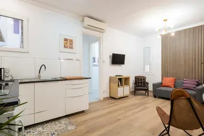 a kitchen and a living room with a couch at Centric Apartment Molino P3 in Barcelona