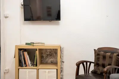 a tv sitting on a wall next to a book shelf at Centric Apartment Molino P3 in Barcelona