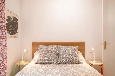 a bedroom with a bed with two lamps on either side at Centric Apartment Molino P3 in Barcelona