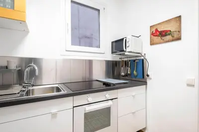a kitchen with white cabinets and a sink and a window at Centric Molino Theatre 1-1 in Barcelona