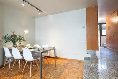 a dining room with a table and white chairs at My Space Emirates - Charming Duplex in Barcelona ideal for Families or Friends in Barcelona