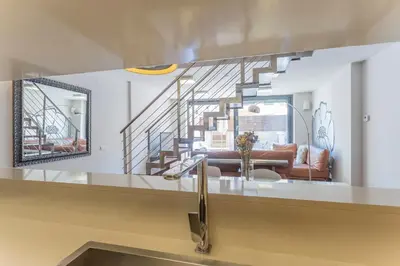 a kitchen with a sink and a living room at My Space Emirates - Splendid Apartment with Terrace and Pool near Park Güell in Barcelona