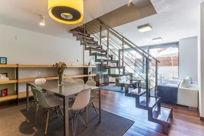 a dining room and living room with a spiral staircase at My Space Emirates - Splendid Apartment with Terrace and Pool near Park Güell in Barcelona