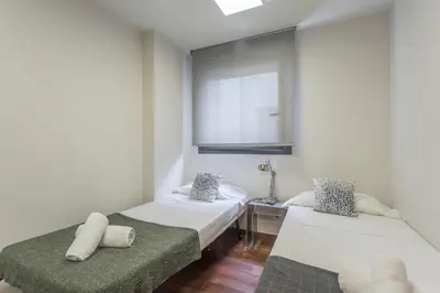 a small room with two beds and a mirror at My Space Emirates - Splendid Apartment with Terrace and Pool near Park Güell in Barcelona
