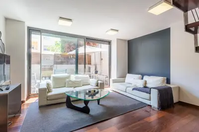a living room with a couch and a table at My Space Emirates - Splendid Apartment with Terrace and Pool near Park Güell in Barcelona
