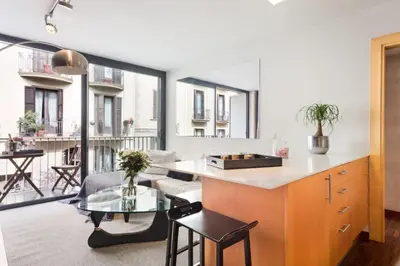 a kitchen and living room with a table and chairs at My Space Emirates - Executive Apartments with Private Balcony in Barcelona