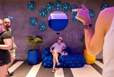 a man sitting in a pile of blue balls at AMISTAT City Hostel Barcelona in Barcelona