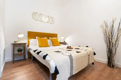 a bedroom with a large bed with yellow pillows at Enamorats Glorias in Barcelona