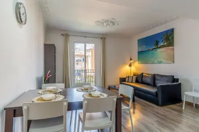 a living room with a table and chairs and a couch at AB Margarit Apartments in Barcelona