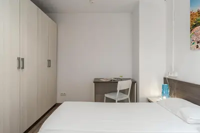 a bedroom with a bed and a desk with a chair at AB Margarit Apartments in Barcelona