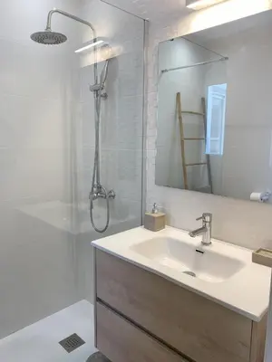 a bathroom with a sink and a shower with a mirror at Ático con terraza! Ideal para vivir Sitges todo el año in Sitges