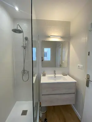 a white bathroom with a sink and a shower at Ático con terraza! Ideal para vivir Sitges todo el año in Sitges