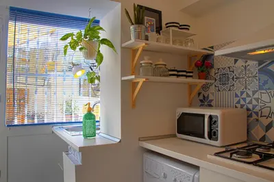 a kitchen with a microwave on a counter next to a window at Casa Tortilla Sant Antoni in Barcelona