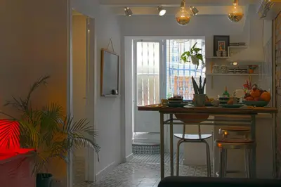 a kitchen with a counter and a table and a window at Casa Tortilla Sant Antoni in Barcelona