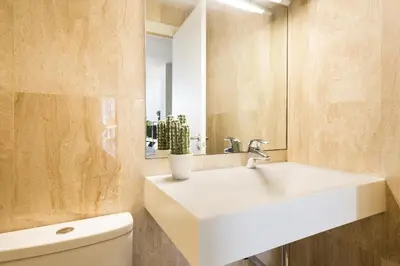 a bathroom with a white sink and a toilet at My Space Emirates - Modern Duplex with Private Garden and Swimming Pool in Barcelona