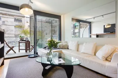 a living room with a white couch and a glass table at My Space Emirates - Spacious Apartments near the City Center in Barcelona