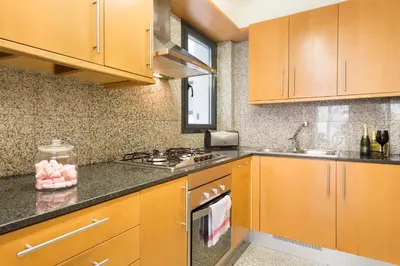a kitchen with wooden cabinets and a stove top oven at My Space Emirates - Spacious Apartments near the City Center in Barcelona
