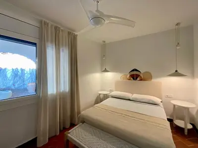 a white bedroom with a bed and a window at SITGES Masia Sències in Sitges