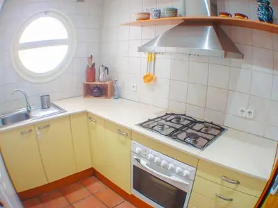 a small kitchen with a stove and a sink at Araia Apartment by Hello Homes Sitges in Sitges