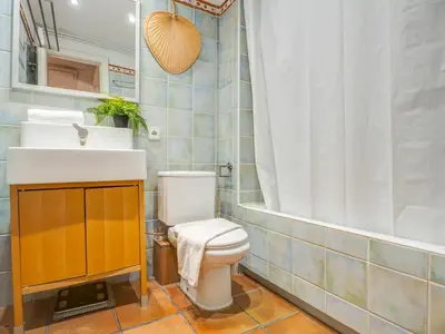 a bathroom with a toilet and a sink and a tub at Araia Apartment by Hello Homes Sitges in Sitges