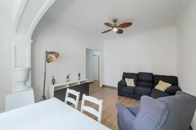 a living room with a couch and a table and chairs at Bed&BCN Mas Apartments in Hospitalet de Llobregat