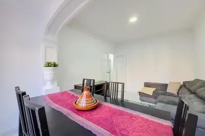 a living room with a table with a vase on it at Bed&BCN Mas Apartments in Hospitalet de Llobregat