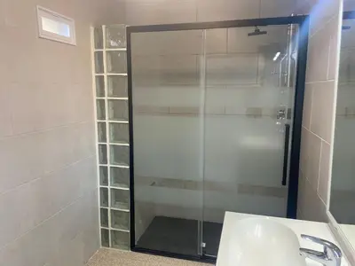 a glass shower in a bathroom with a sink at La Geneta Casa Vacacional in Vilobi Del Penedes
