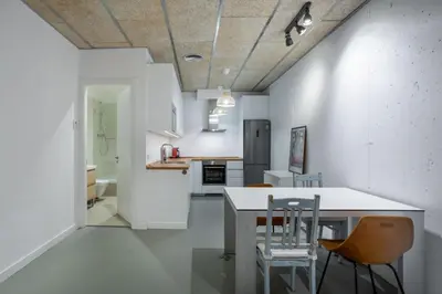 a kitchen with a table and chairs in a room at Loft estilo industrial en Esplugues - 15 min de Barcelona in Esplugues de Llobregat
