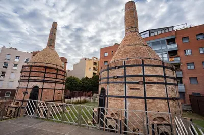 two old brick towers are sitting in a city at Loft estilo industrial en Esplugues - 15 min de Barcelona in Esplugues de Llobregat